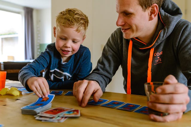 Jongen doet kaartspel met vader