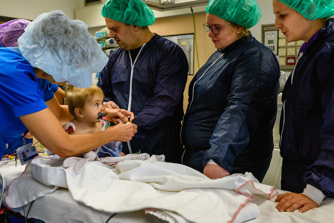 Kind met speen en ouders op operatietafel in ziekenhuis