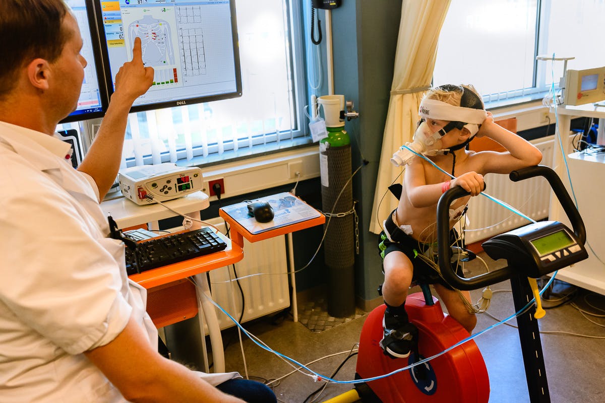 Jongen doet inspanningstest op crosstrainer in ziekenhuis