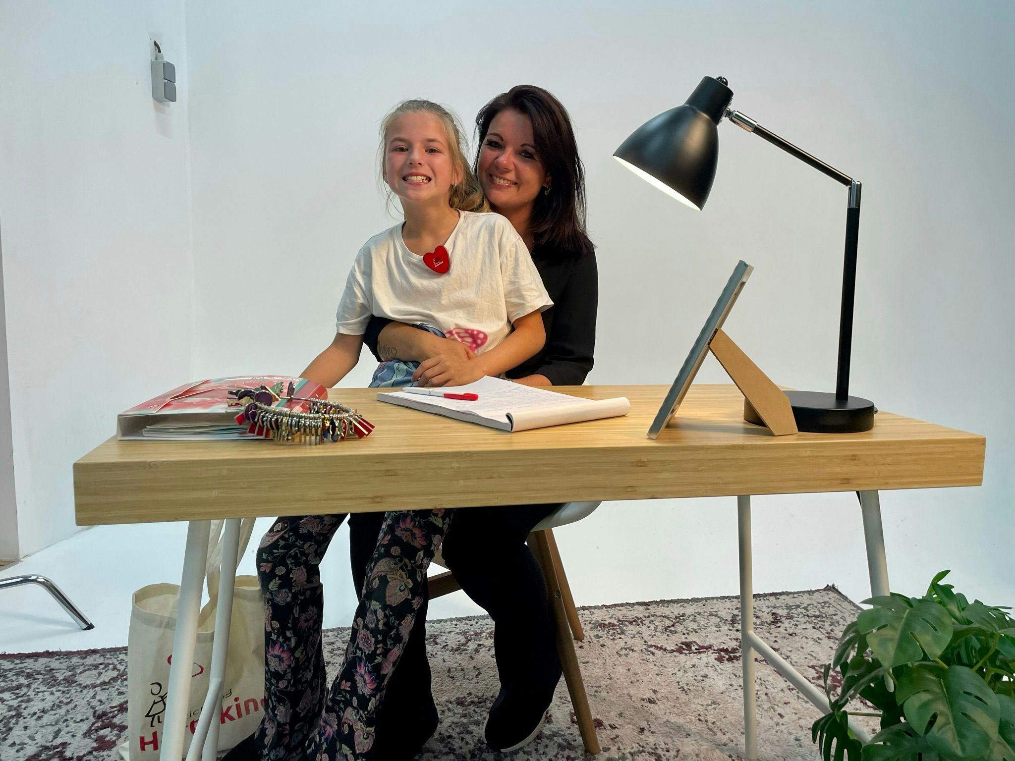 Moeder en dochter lachend achter bureau