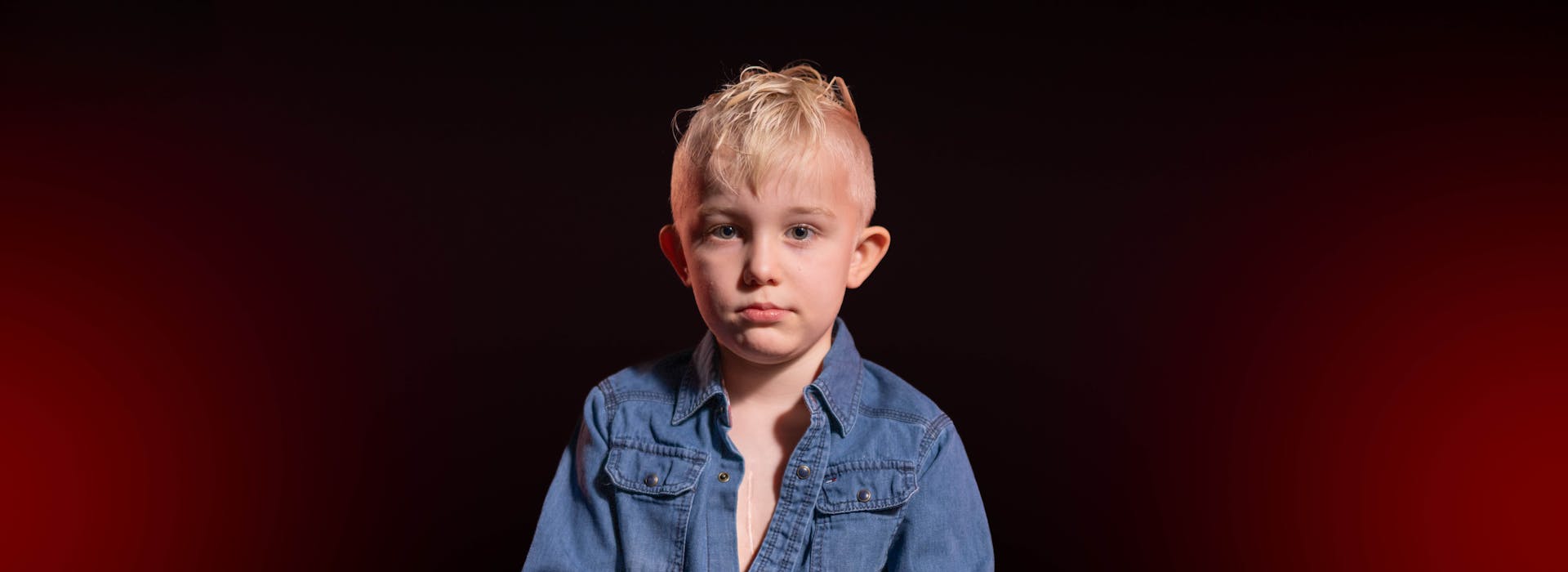 Jongen met litteken op borst zittend op kruk